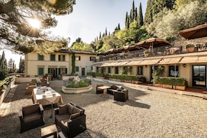 A courtyard with outdoor seating, a pool, and a building with multiple balconies.