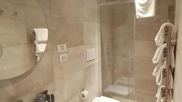 Une salle de bain avec une douche à parois de verre, un lavabo, des toilettes et un miroir.