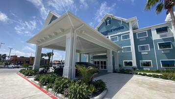L’entrée d’un hôtel, avec un espace d’attente abrité, une enseigne indiquant « Candlewood Suites » et une ligne indiquant « Stationnement interdit ».