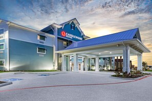 A hotel with a modern design, featuring a prominent "Candlewood Suites" sign.