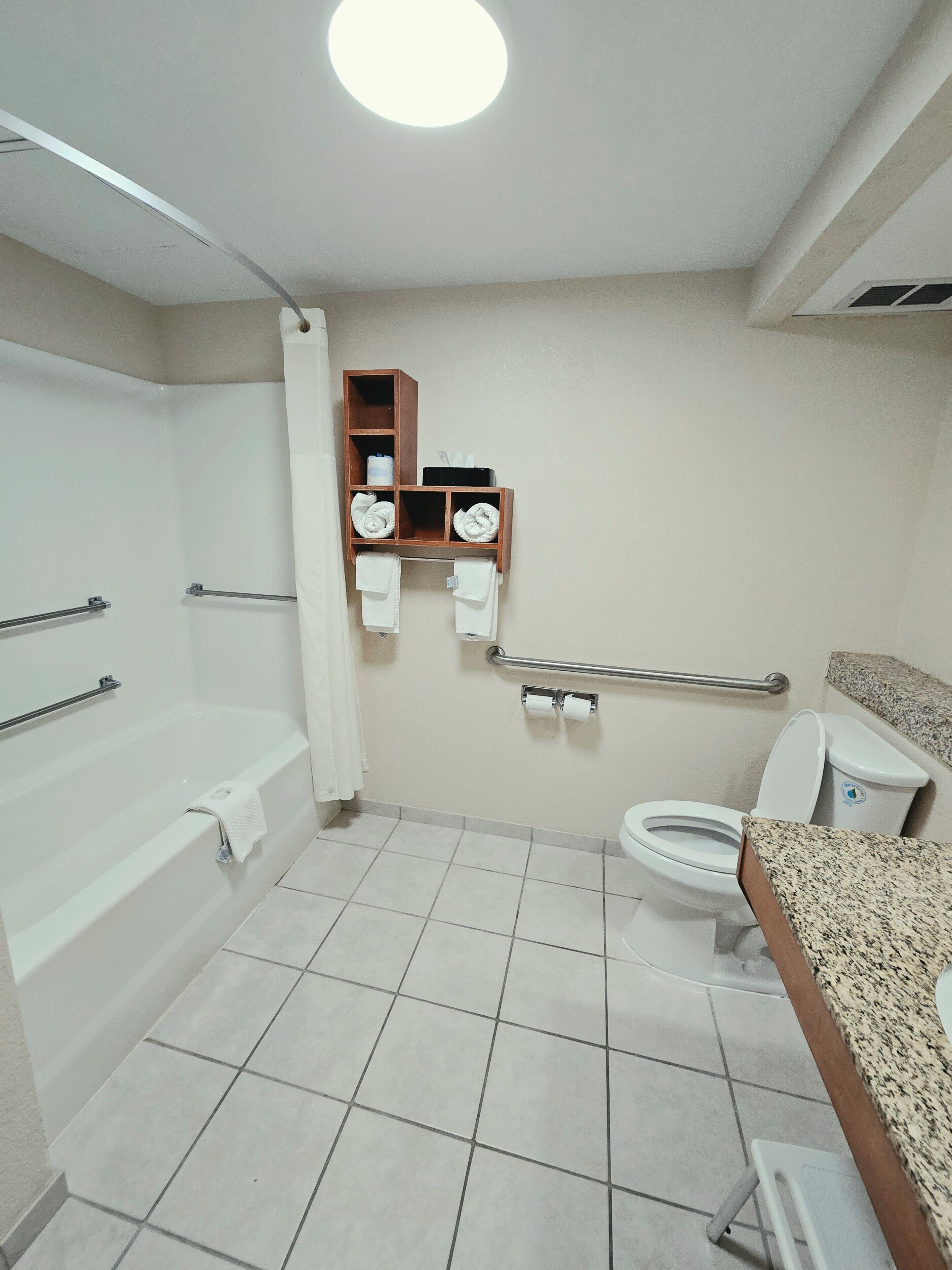 Ein Badezimmer mit Badewanne, Toilette und einem Handtuchregal.