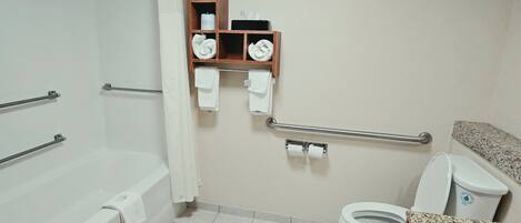 Un baño con bañera, inodoro y un estante con toallas.