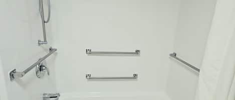 A white bathtub with a showerhead and grab bars.