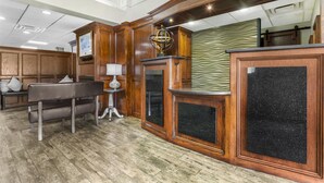 A wooden reception desk with a globe, a bench, and a patterned wall. - Best Western Plus Yukon (Yukon)