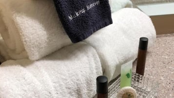 A white towel with a black label that reads "Makeup Remover" and two small bottles on a tray.