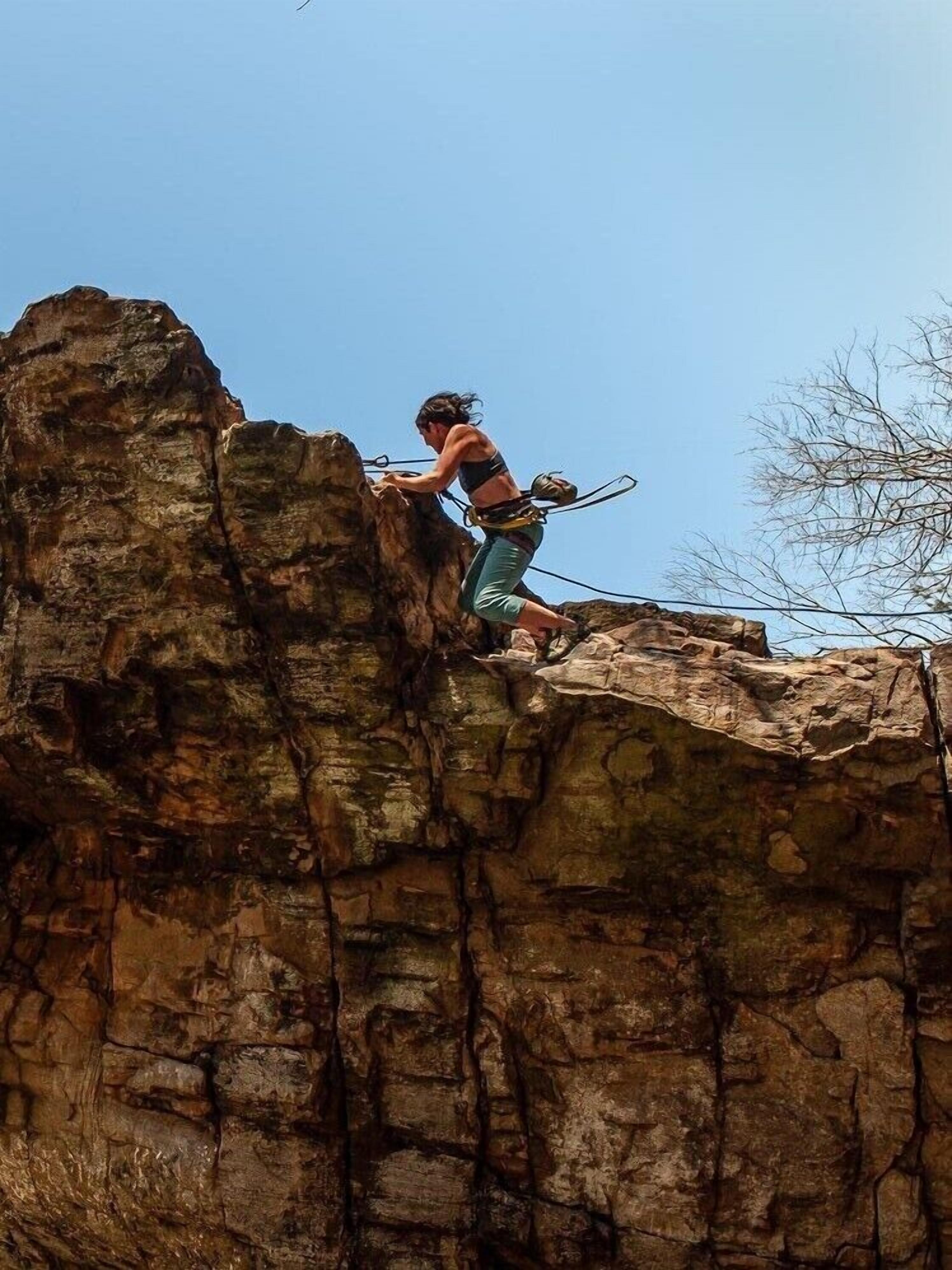 Une personne qui escalade une falaise rocheuse.