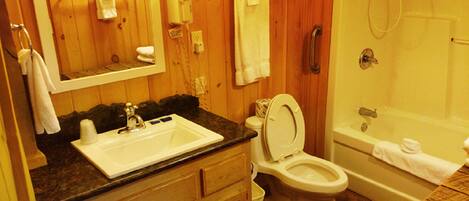 Ein Badezimmer aus Holz mit Waschbecken, Toilette und Badewanne.