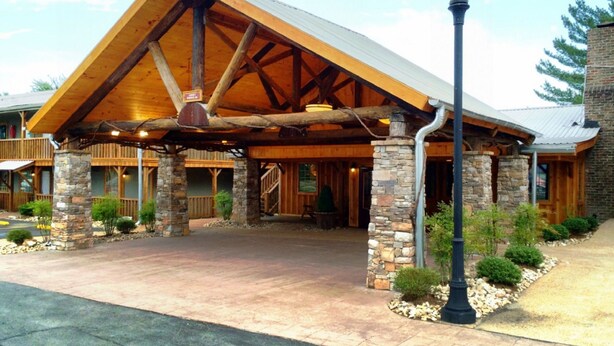 A lodge with a large wooden overhang, stone pillars, and a stone entrance. - The Smokehouse Lodge and Cabins (Monteagle)