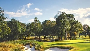 A golf course with sand bunkers, trees, and a clear sky. - The Smokehouse Lodge and Cabins (Monteagle)