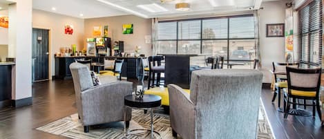 A hotel lobby with a seating area, a bar, and a large window.