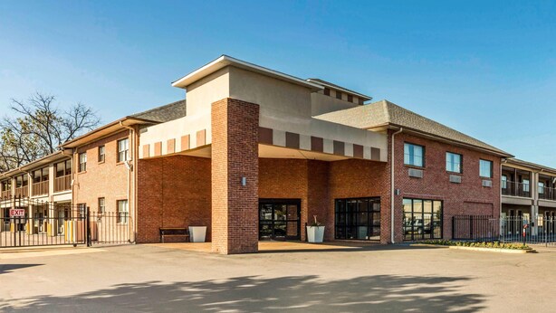A multi-story building with a flat roof, large windows, and a brick facade.