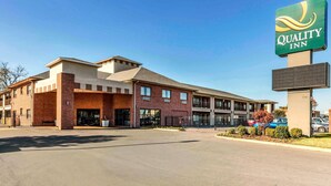A Quality Inn hotel with a brick facade, a large sign, and a parking lot.