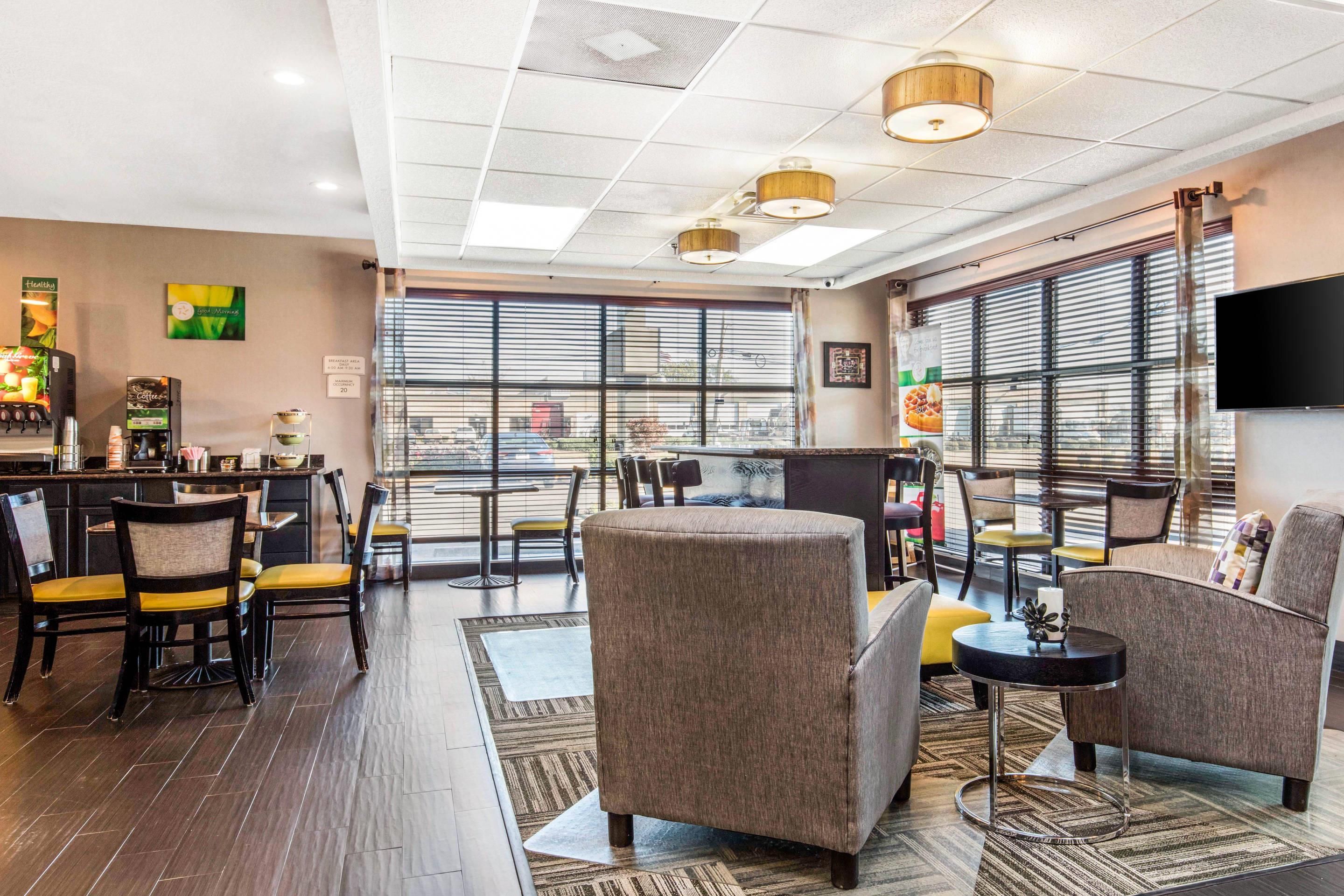 A modern hotel lobby with a bar area, seating, and large windows.