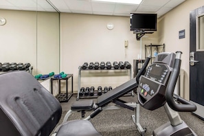 A gym with exercise equipment, including treadmills, dumbbells, and a stationary bike.