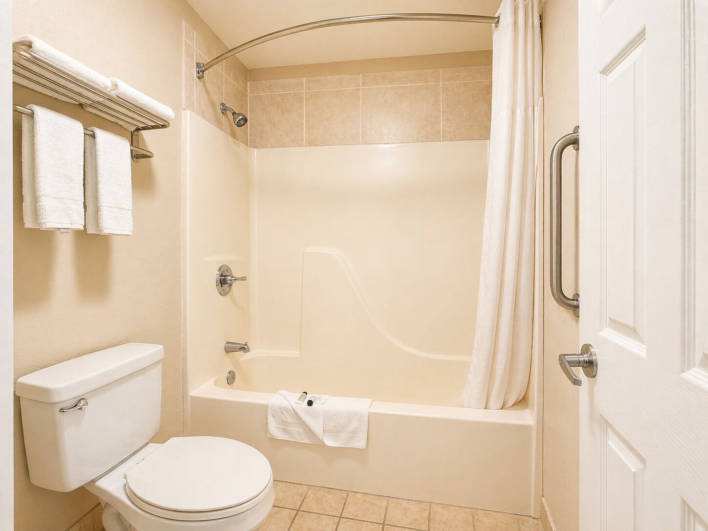A bathroom with a toilet, bathtub, shower, and a towel rack.