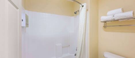Un baño con bañera, inodoro y un perchero para toallas.