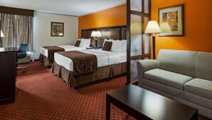 A hotel room with two beds, a sofa, a desk, and a lamp. - Baymont by Wyndham Lubbock (Lubbock)