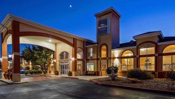 A hotel with a prominent entrance, a brick facade, and a sign indicating it is a Baymont by Wyndham. - Baymont by Wyndham Lubbock (Lubbock)