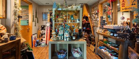 A cozy, well-stocked retail store with shelves of various items, including toys and home decor.