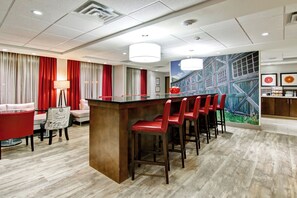 A hotel lobby with a bar area, seating, and a mural on the wall. - Canalta Hotel Hanna (Hanna)