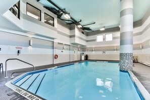 An indoor swimming pool with clear lane markings, emergency telephone signs, and a lifebuoy. - Best Western Plus Cambridge Hotel (Cambridge)