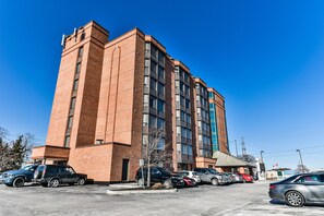A multi-story brick building with a parking lot in front. - Best Western Plus Cambridge Hotel (Cambridge)