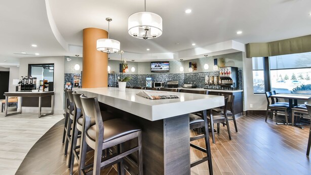 Una cocina moderna con una isla central, barra y asientos.