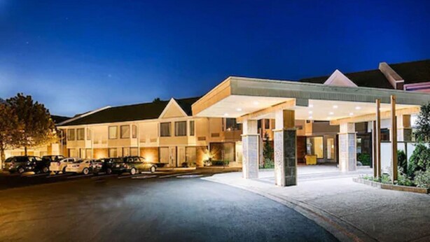 A hotel with a covered entrance, a parking lot, and a well-lit facade. - Quality Inn & Suites (Brampton)