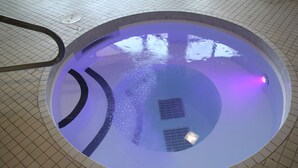 A circular indoor pool with a tiled floor and a central drain. - Quality Inn & Suites (Brampton)