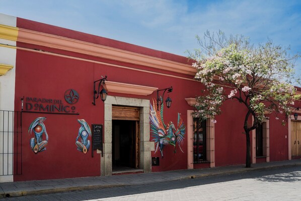 Un bâtiment rouge sur lequel on peut lire l’inscription « PARADER DEL DOMINICO », et une fresque colorée représentant un paon.