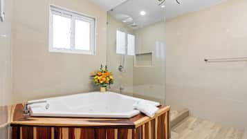 A modern bathroom with a freestanding bathtub, a glass shower enclosure, and a wooden vanity.