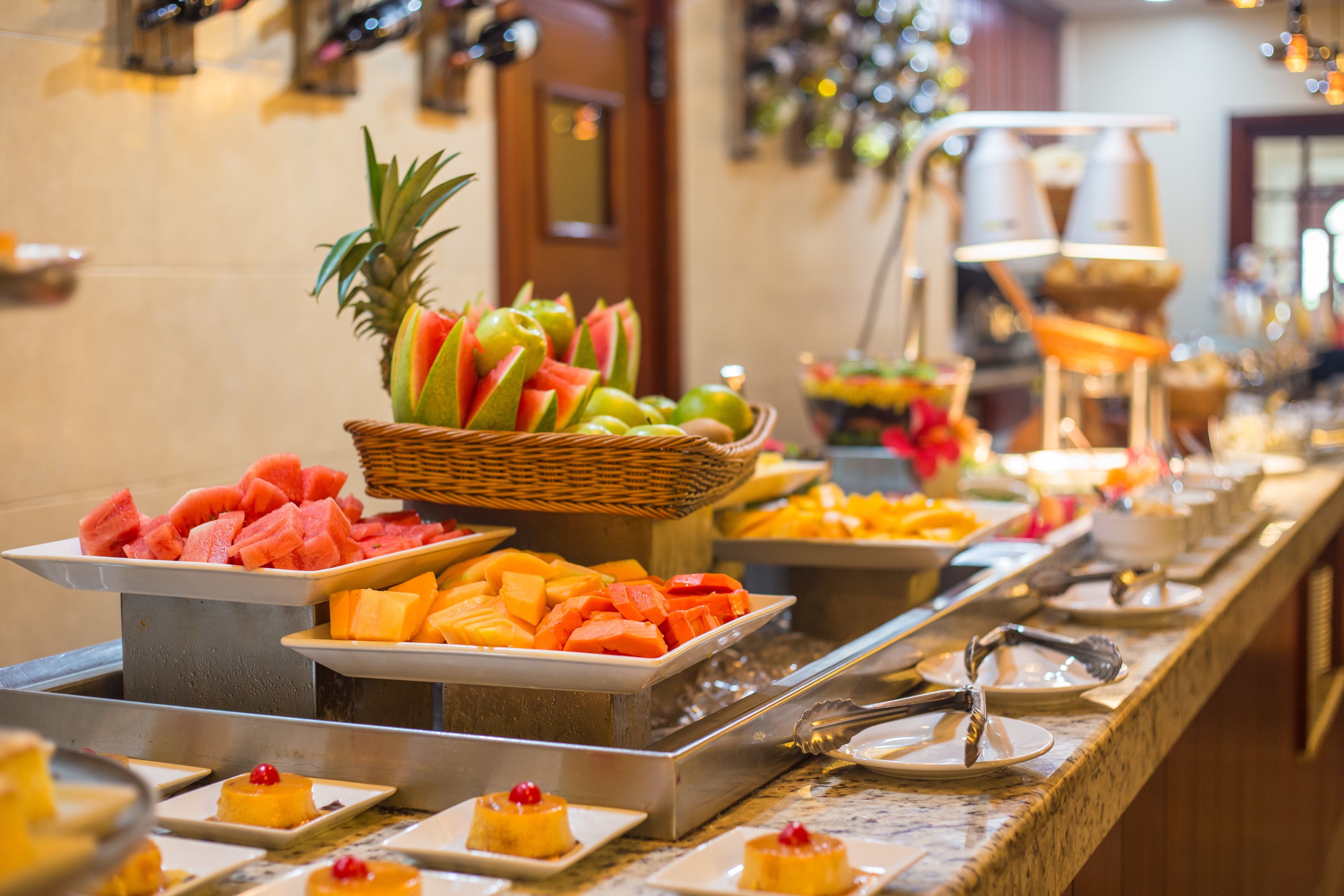 Un bufé con diversas frutas y postres.