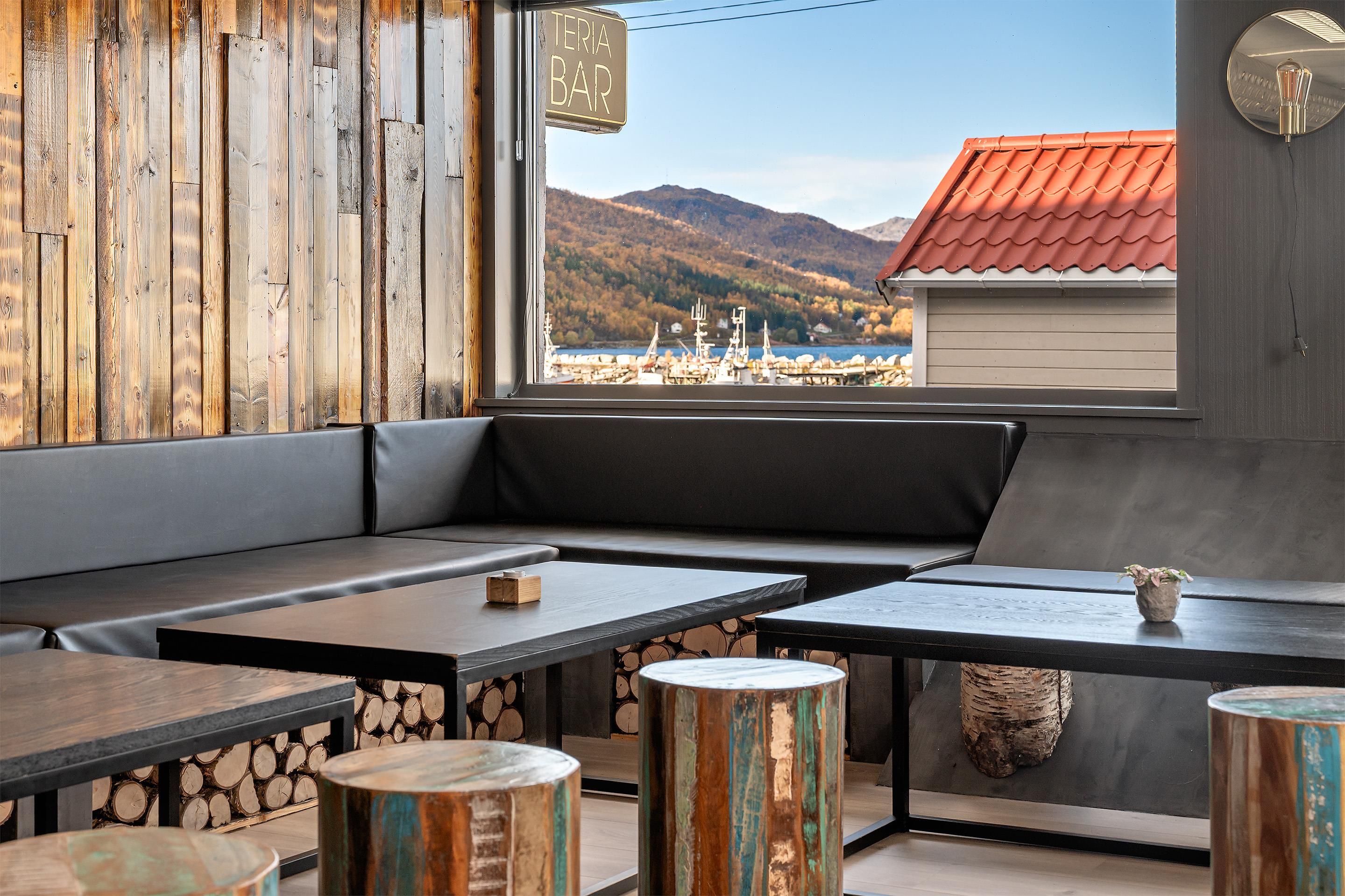 Ein gemütlicher Sitzbereich mit Blick auf einen Hafen und Berge.