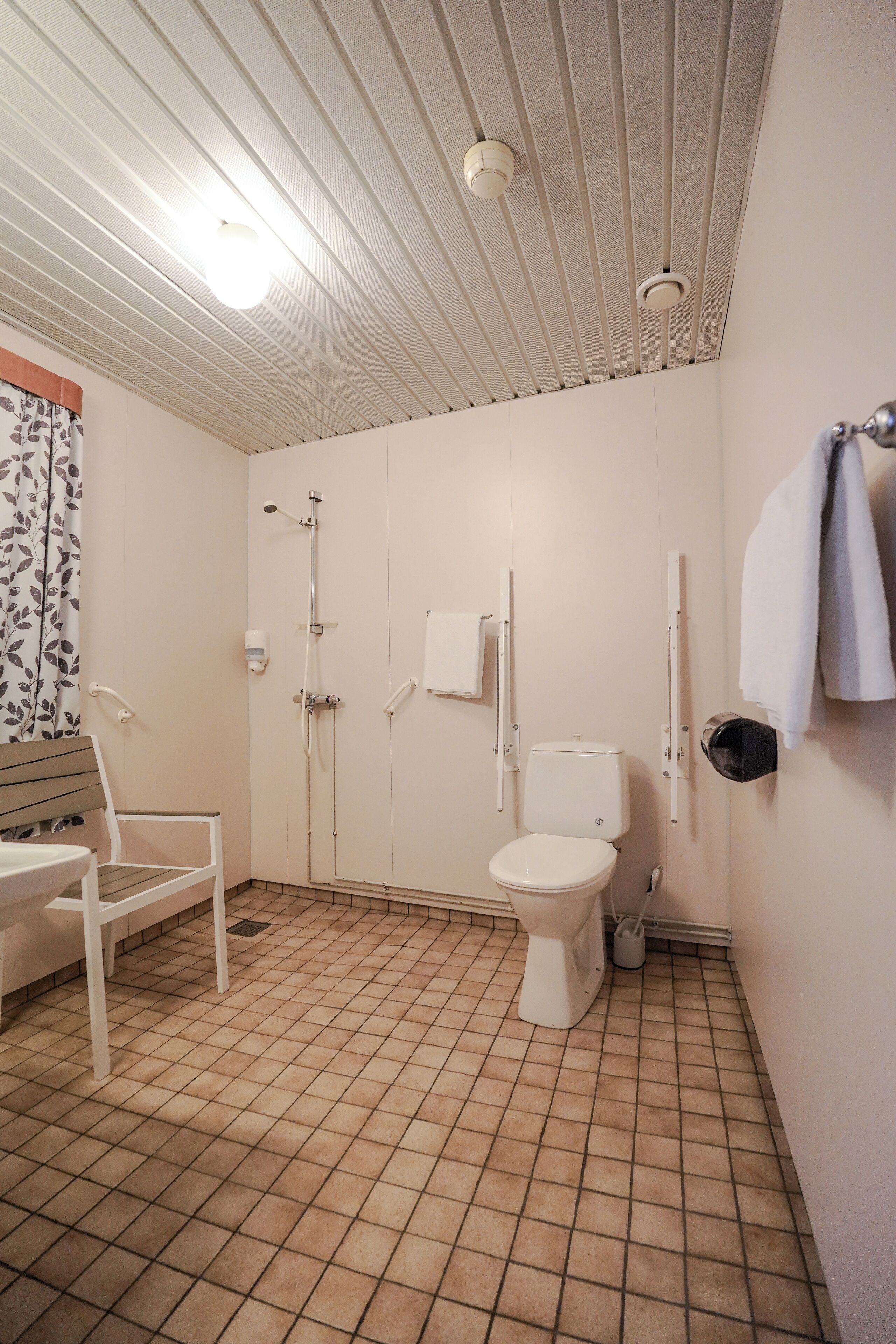 A bathroom with a toilet, shower, and sink.