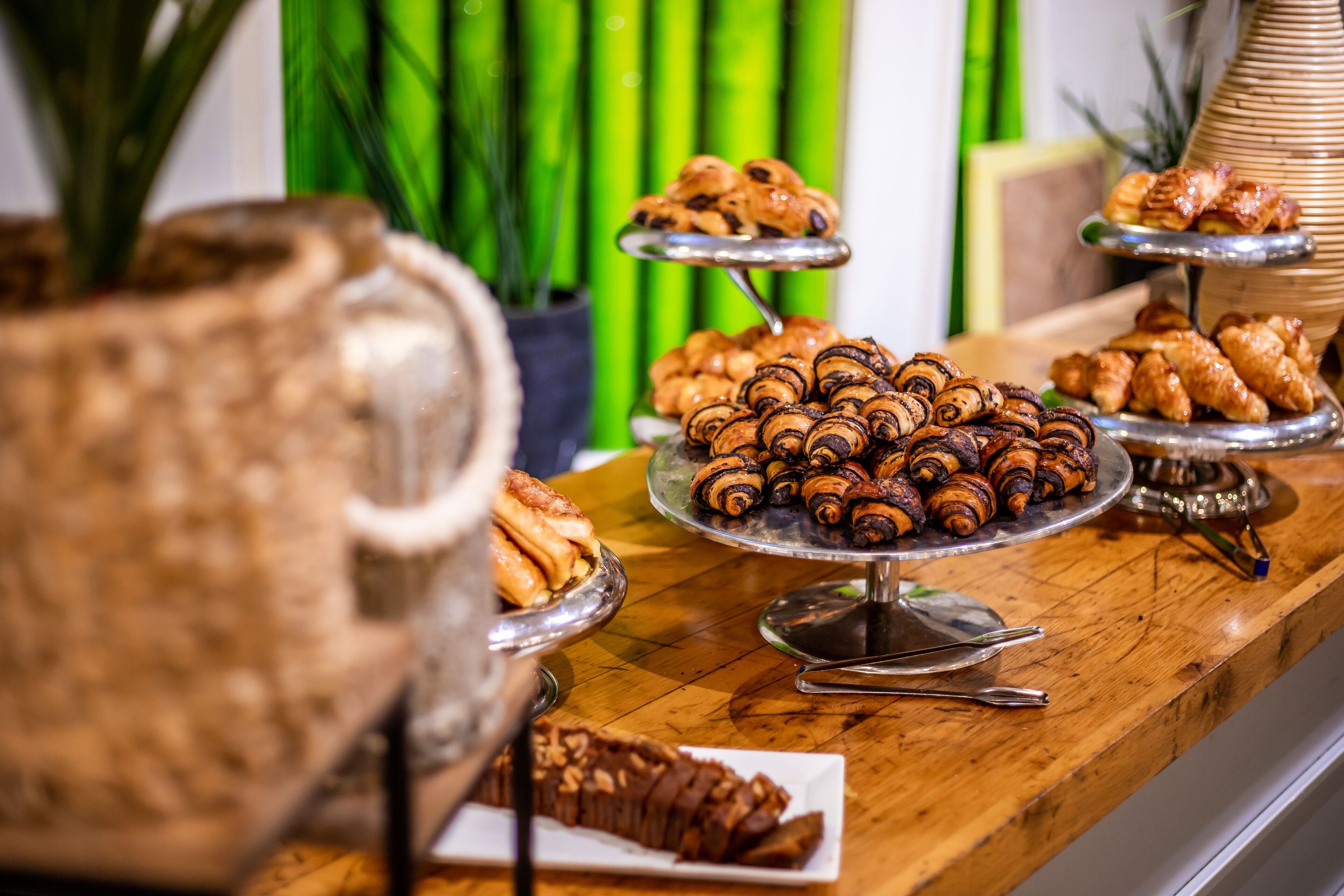 Una mesa de buffet con diversos pasteles y una jarra de agua.