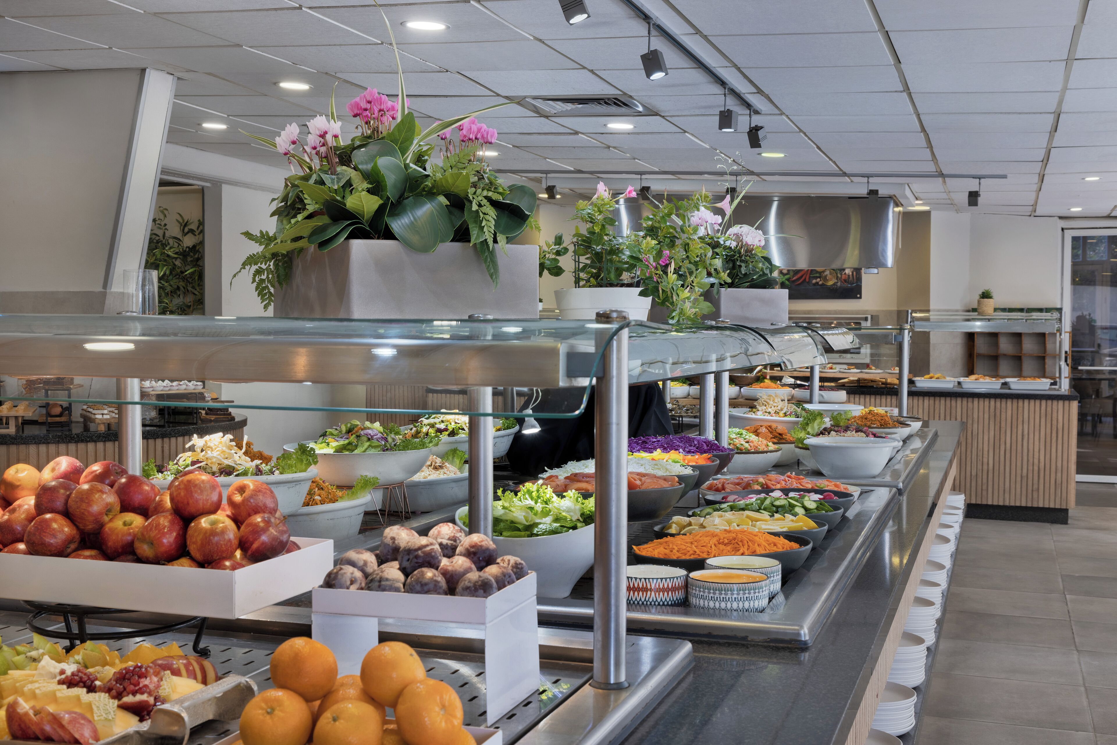 A buffet with various food items, including fruits, vegetables, and salads.