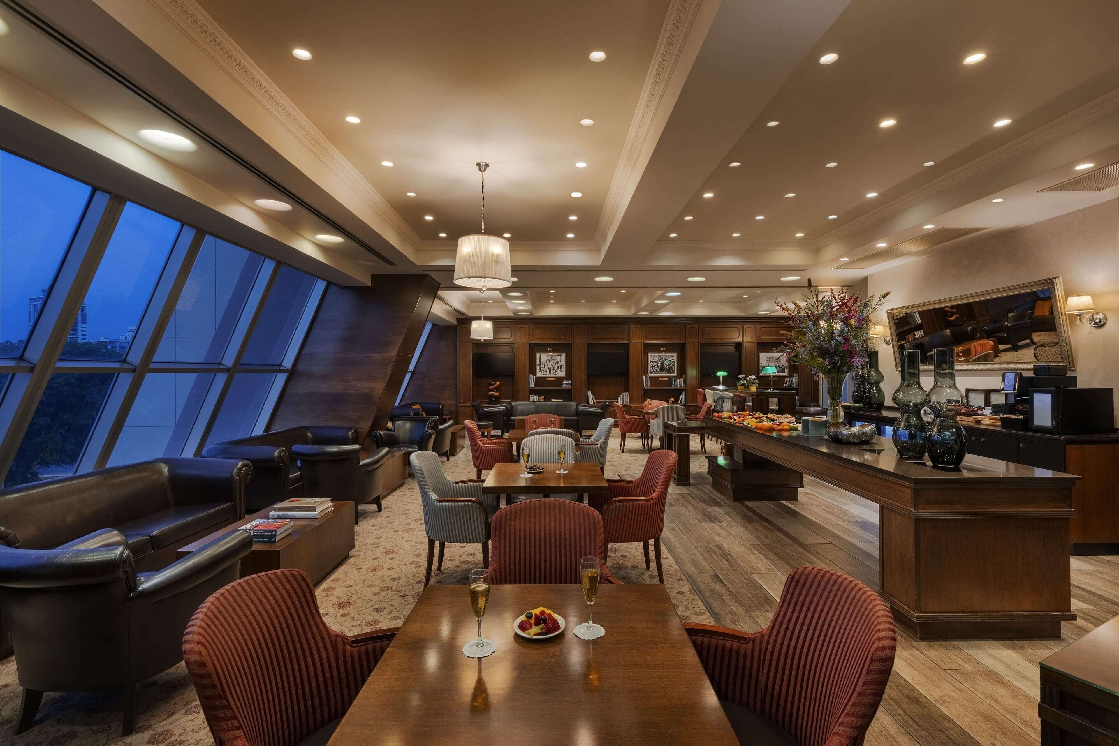 Eine moderne Hotelhalle mit Essbereich, Sitzgelegenheiten und einer Rezeption.
