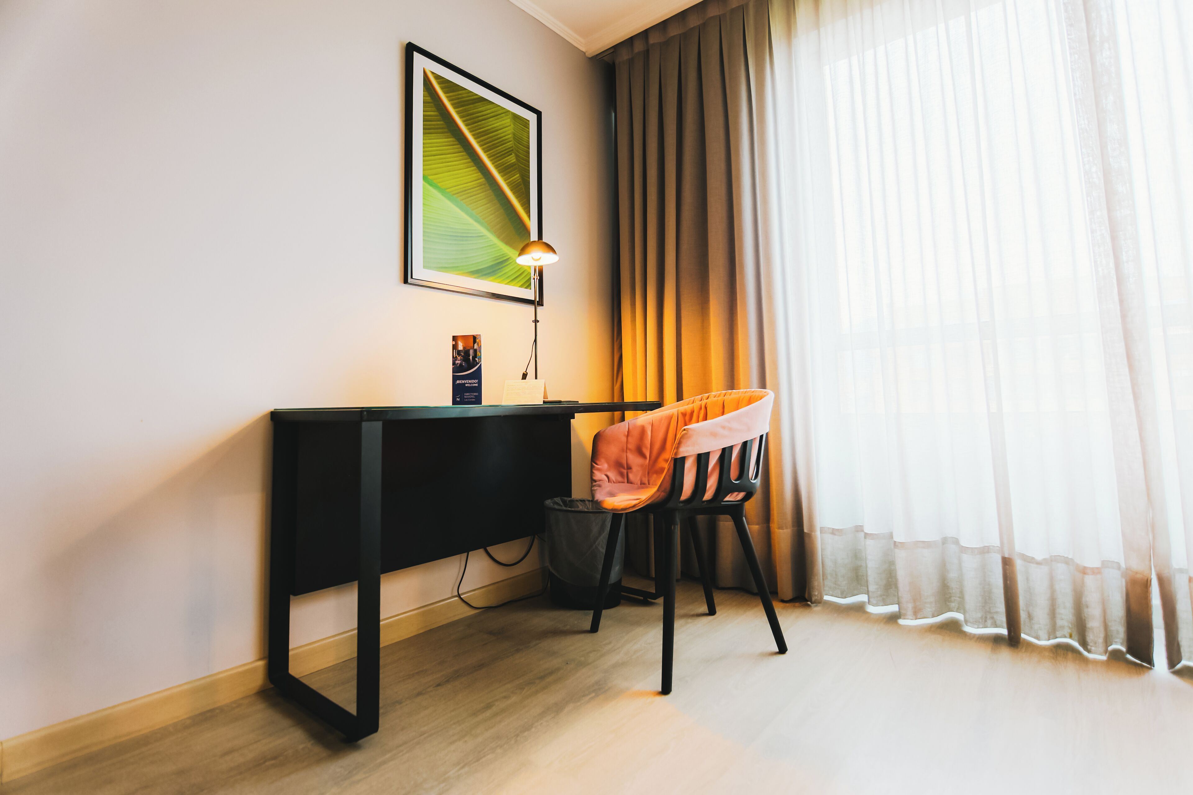 A modern room with a desk, chair, and a framed picture on the wall.