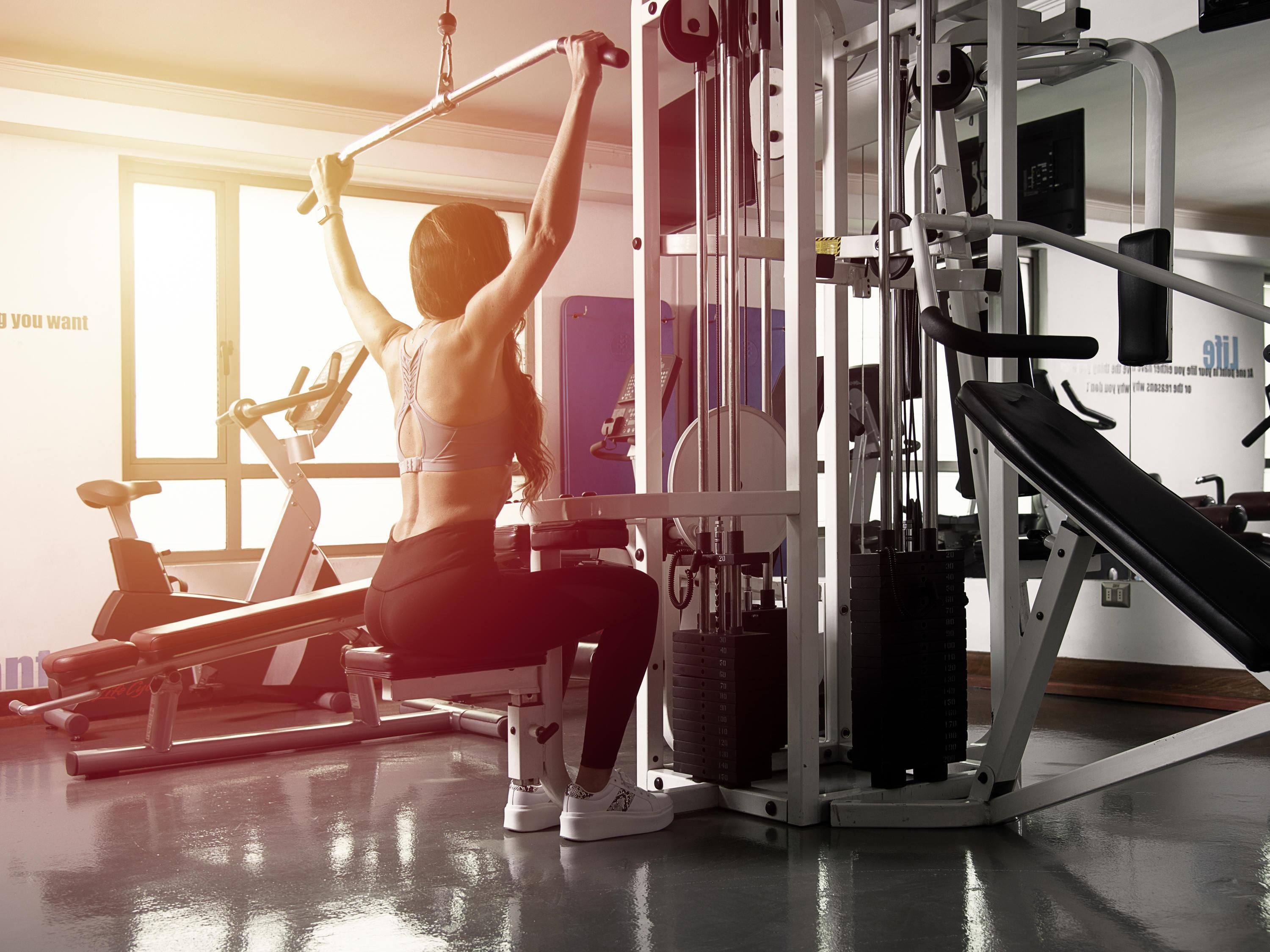 Un gimnasio con equipo de ejercicio, una ventana y una pared con texto.