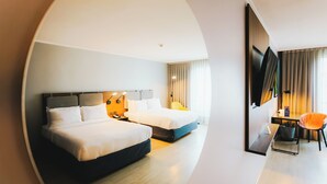 Een hotelkamer met twee bedden, een bureau, een stoel en een televisie.