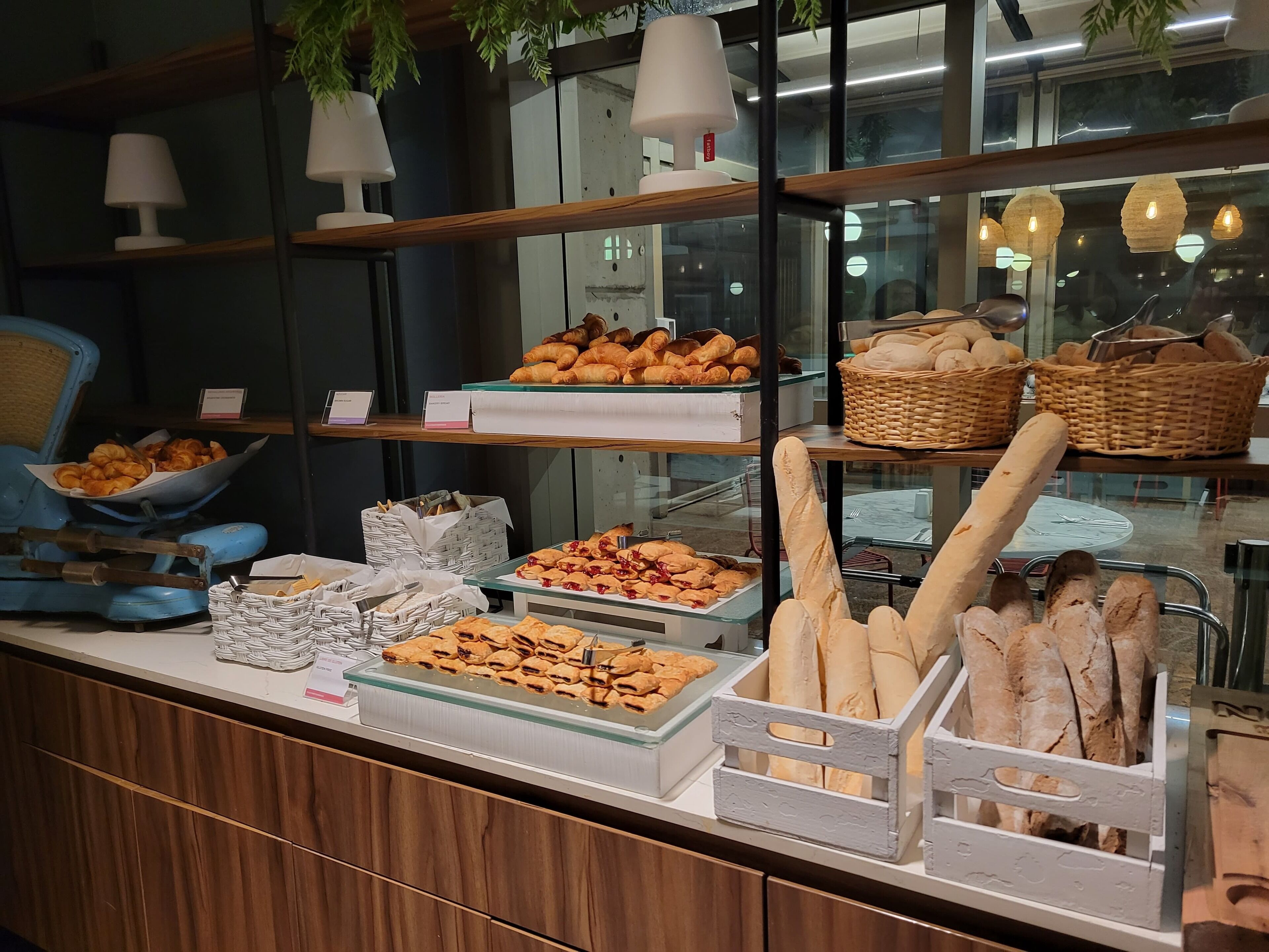 Eine Bäckertheke mit verschiedenen Backwaren, darunter Croissants und Brot, in einem Geschäft.