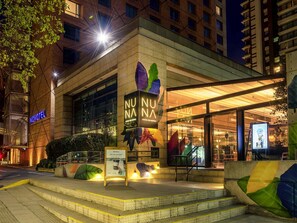 A hotel with a modern facade, a visible entrance, and a sign for a coffee shop. - Novotel Santiago Las Condes (Santiago)