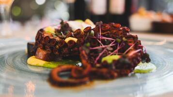 Un plato de pulpo con verduras y salsa.