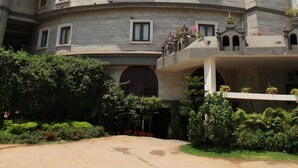 Un hotel de estilo castillo con múltiples torres, un letrero que dice "Bestwestern Amritsar" y un jardín bien cuidado al frente.