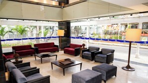 A hotel lobby with seating arrangements, a coffee table, and a lamp. - Plaza Praia Suites (Fortaleza)