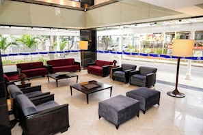 A hotel lobby with seating arrangements, a coffee table, and a lamp. - Plaza Praia Suites (Fortaleza)