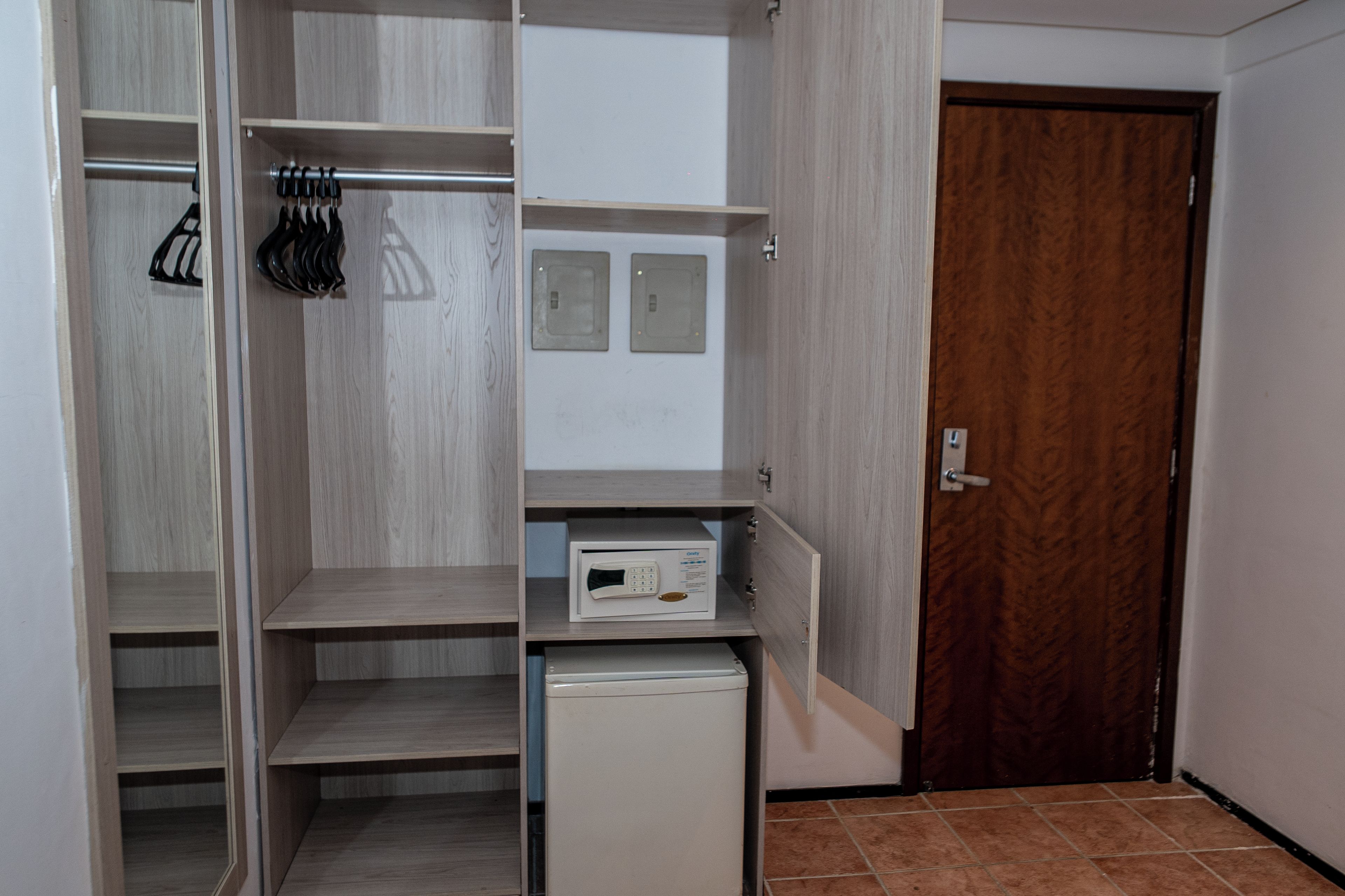 Un vestidor con estantes abiertos, un electrodoméstico y una puerta de madera.