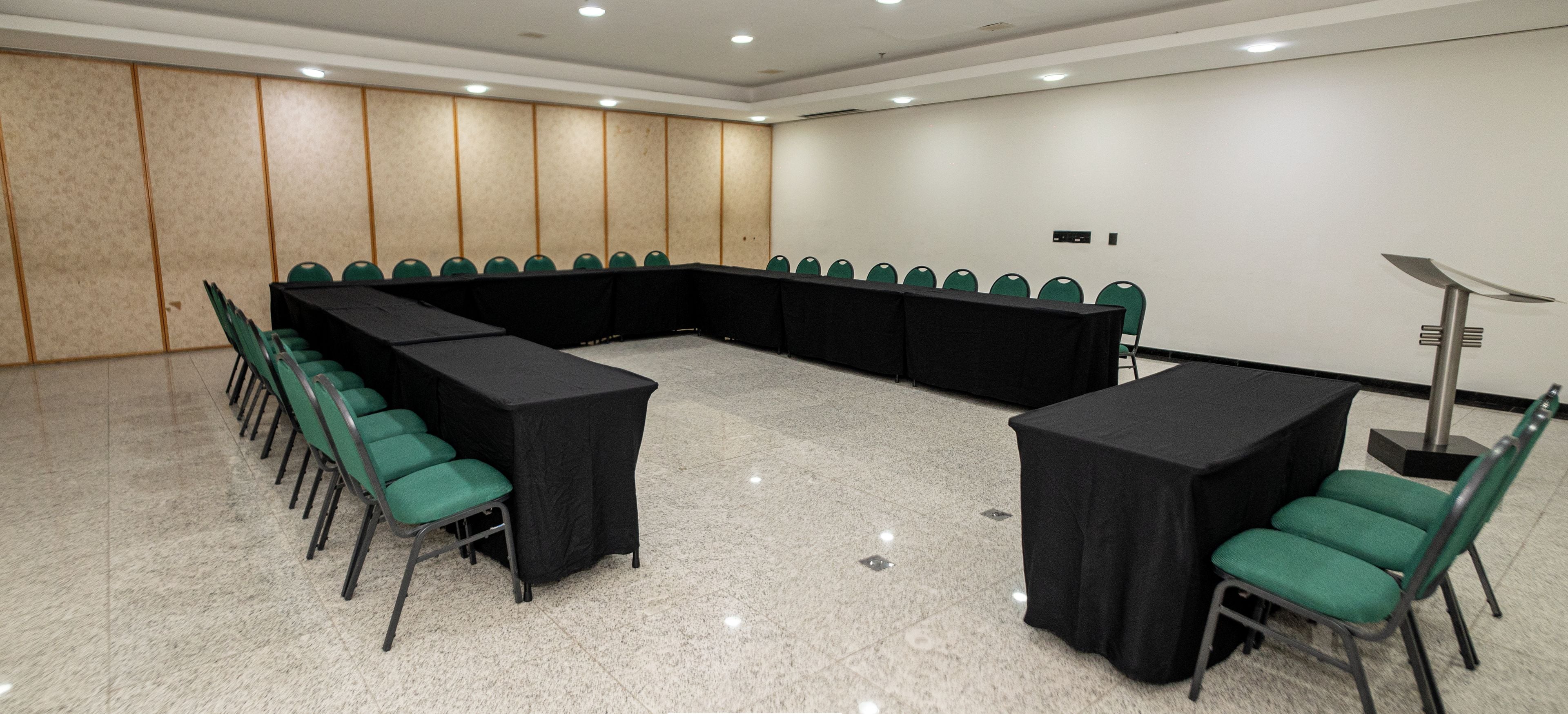 Una sala de conferencias con una larga mesa, sillas y un proyector.
