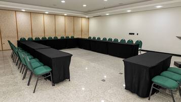 Una sala de conferencias con una larga mesa, sillas y un proyector.