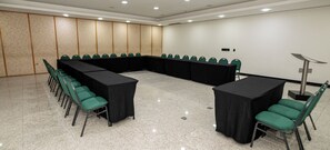 A conference room with a long table, chairs, and a projector.